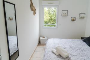 a white bedroom with a bed and a mirror at Evasion chic in Marseille