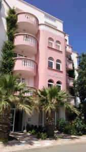 プリモルスコにあるGuest House Malkata Stopankaのヤシの木が目の前に広がるピンクの建物