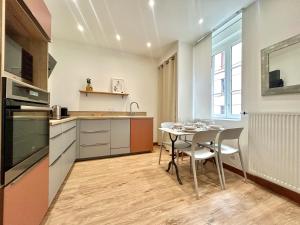 a kitchen with a table and chairs in a room at Maison Dormoy, appartement 2 Chambre - Gare - Centre ville in Grenoble