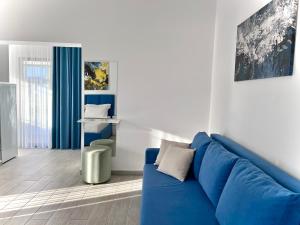 a living room with a blue couch and a table at Dine Hotel in Ksamil