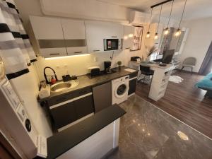 a kitchen with a sink and a washing machine at Paloma Blanca 2 in Gárdony