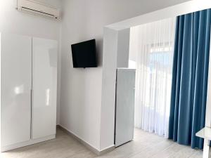 a white room with a refrigerator and a window at Dine Hotel in Ksamil