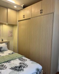 - une chambre avec 2 lits et des placards en bois dans l'établissement Mazal Residence, à Manille