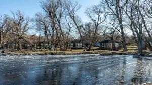Un estanque congelado en un parque con árboles y edificios. en 2-bedroom Lake Front Cottage in Harwood ON #4, en Harwood 25 fotos más
