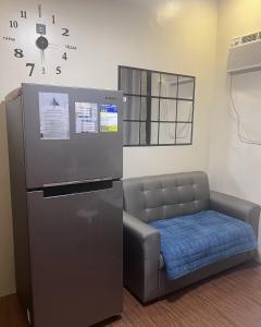 - une chaise à côté d'un réfrigérateur dans la chambre dans l'établissement Mazal Residence, à Manille