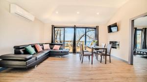 a living room with a couch and a table at 2-bedroom Lake Front Cottage in Harwood ON #1 in Harwood