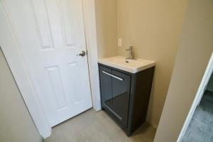 baño con lavabo y puerta blanca en 1-bedroom Townhouse in Harwood #3, en Harwood