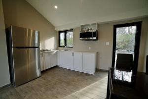 a kitchen with a stainless steel refrigerator and white cabinets at 1-bedroom Townhouse in Harwood #2 in Harwood
