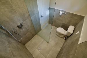 a bathroom with a toilet and a glass shower at 1-bedroom Townhouse in Harwood #2 in Harwood
