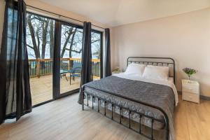 a bedroom with a bed and a balcony at 2-bedroom Lake Front Cottage in Harwood ON #7 in Harwood