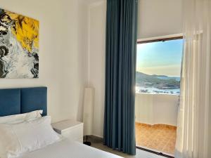 a bedroom with a bed and a window with a view at Dine Hotel in Ksamil