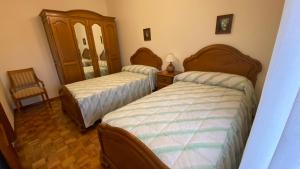een slaapkamer met twee bedden en een spiegel bij Piso Brisa de Barreiros in San Cosme de Barreiros +16 foto's
