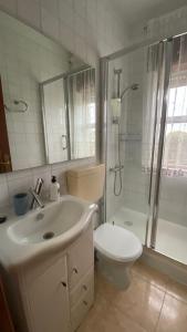 a bathroom with a sink and a shower and a toilet at Piso Brisa de Barreiros in San Cosme de Barreiros +16 photos