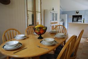 una mesa de madera con platos y cuencos encima en Twisted Gum Vineyard Cottage, en Ballandean