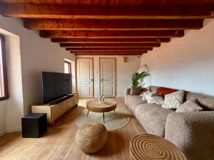 a living room with a couch and a tv at Charming stone house in Eus - Vue sur les Montagnes & Confort 2025 in Eus