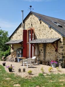 a building with two chairs and a table in front of it at Gîte La Sarrée in Onlay