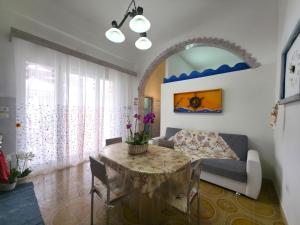a living room with a table and a couch at Villa Sette Nani in Torre Lapillo
