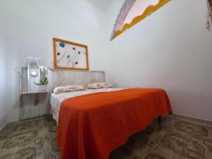 a bedroom with a bed with an orange blanket at Villa Sette Nani in Torre Lapillo
