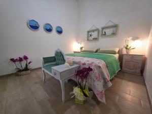a bedroom with a bed and a table and a chair at Villa Sette Nani in Torre Lapillo