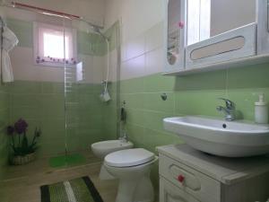 a bathroom with a white sink and a toilet at Villa Sette Nani in Torre Lapillo