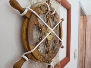 a wooden fan hanging on a wall next to a mirror at Villa Sette Nani in Torre Lapillo