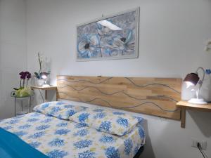 a bedroom with a bed and a picture on the wall at Villa Sette Nani in Torre Lapillo
