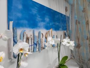 a wall with some white flowers and a blue painting at Villa Sette Nani in Torre Lapillo