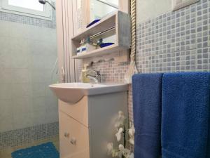 a bathroom with a sink and blue towels at Villa Sette Nani in Torre Lapillo