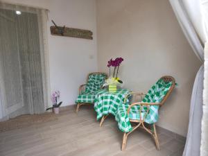 two chairs and a table with a green and white table cloth at Villa Sette Nani in Torre Lapillo