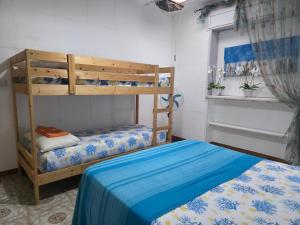 a bedroom with two bunk beds and a blue bed at Villa Sette Nani in Torre Lapillo