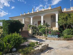 a large white house with plants in front of it at Villa Sette Nani in Torre Lapillo