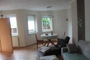 a living room with a couch and a table at Hunsrücktraum in Mittelstrimmig +7 photos
