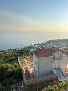 an aerial view of a building with the ocean behind it at Guesthouse Mateo in Dhërmi