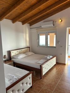 a bedroom with two beds and a window at Guesthouse Mateo in Dhërmi