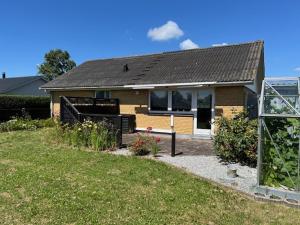 a small house with a garden and a greenhouse at Hus i ét plan in Rødby