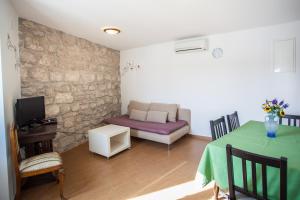 a living room with a couch and a table at Apartment Pogled na luku in Cres