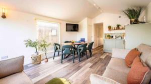 a living room with a couch and a table and chairs at Whitemills Wake and Aqua Park Lodge Five in Richborough