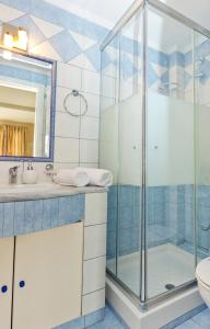 a bathroom with a glass shower and a sink at Aegean Sun Hotel in Skala Rachoniou +25 photos