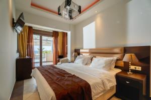 a bedroom with a large bed and a window at Meliton Inn Hotel & Suites by the beach in Neos Marmaras