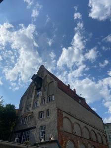 a tall brick building with a sky in the background at Ferienwohnung Altstadt Frankenstraße in Stralsund