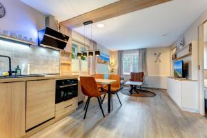 een keuken met een tafel en stoelen in een kamer bij Dünenhäuser Ückeritz UnserUsedomDe FeWo ca40qm mit Parkplatz direkt am Strand 9I1 in Ueckeritz +14 foto's