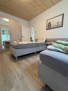 a bedroom with two beds and a couch at Modernes Haus am See, Ferienhaus Gavner im Seepark Lehe in Wiefelstede