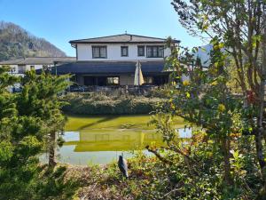 a house with a pond in front of it at Le Cavalier Delémont in Soyhières