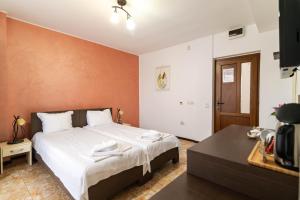 a bedroom with a large white bed and a table at Rosiem House in Techirghiol