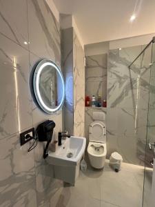 a bathroom with a sink and a mirror and a toilet at RbNb Shengjin in Shëngjin
