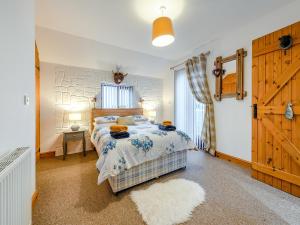 Schlafzimmer mit einem Bett und einer Holztür in der Unterkunft The Granary - Uk41502 in Saint Twynnells + 14 Fotos