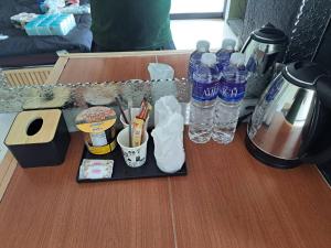 a table with a tray with bottles of water on it at เอส ที โฮมสเตย์ นครนายก in Ban Hin Dat