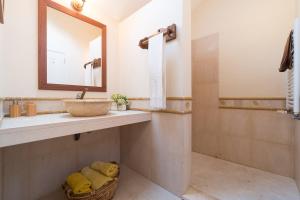 a bathroom with a sink and a mirror and a shower at Luxury VILLA CAMÉLIA. Mountains, golf, horses, levada walks. in Santo da Serra +111 photos