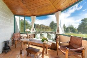 a living room with a table and chairs and a large window at Luxury VILLA CAMÉLIA. Mountains, golf, horses, levada walks. in Santo da Serra