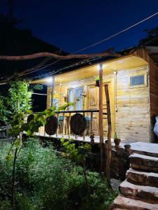 a wooden house with lights on the side of it at Vardzia Chachkari Cottage in Gogasheni